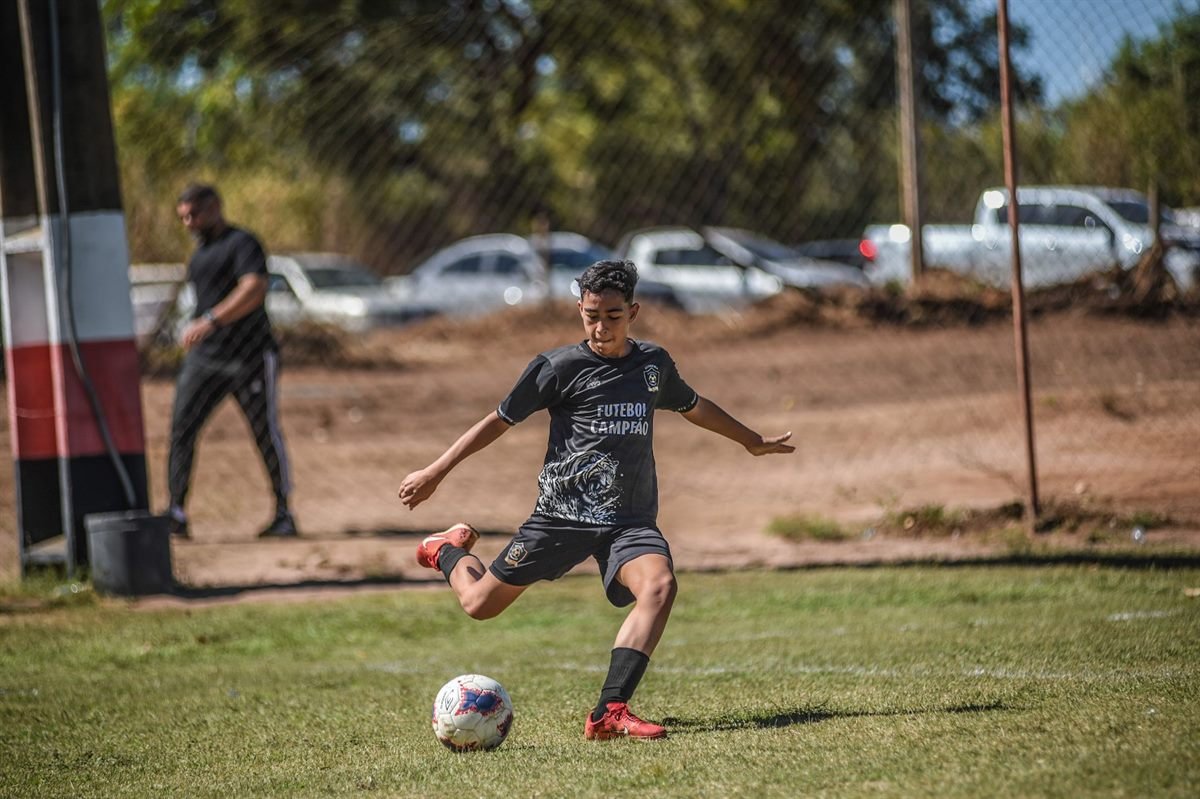 Atleta da Futebol Campeão finalizando a gol durante partida
