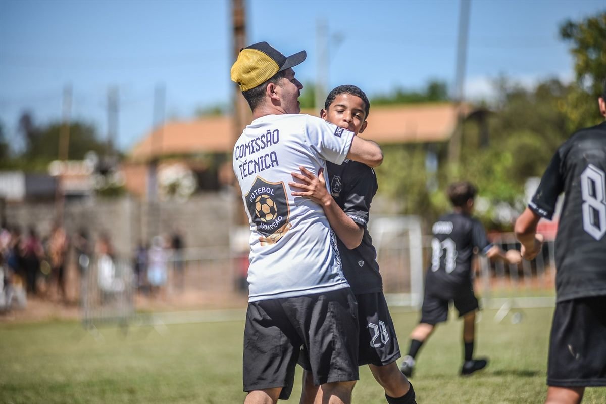 Integrante da comissão técnica abraça o atleta em campo